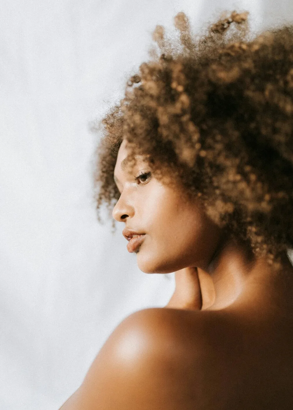 A woman with calm, healthy skin in soft natural light